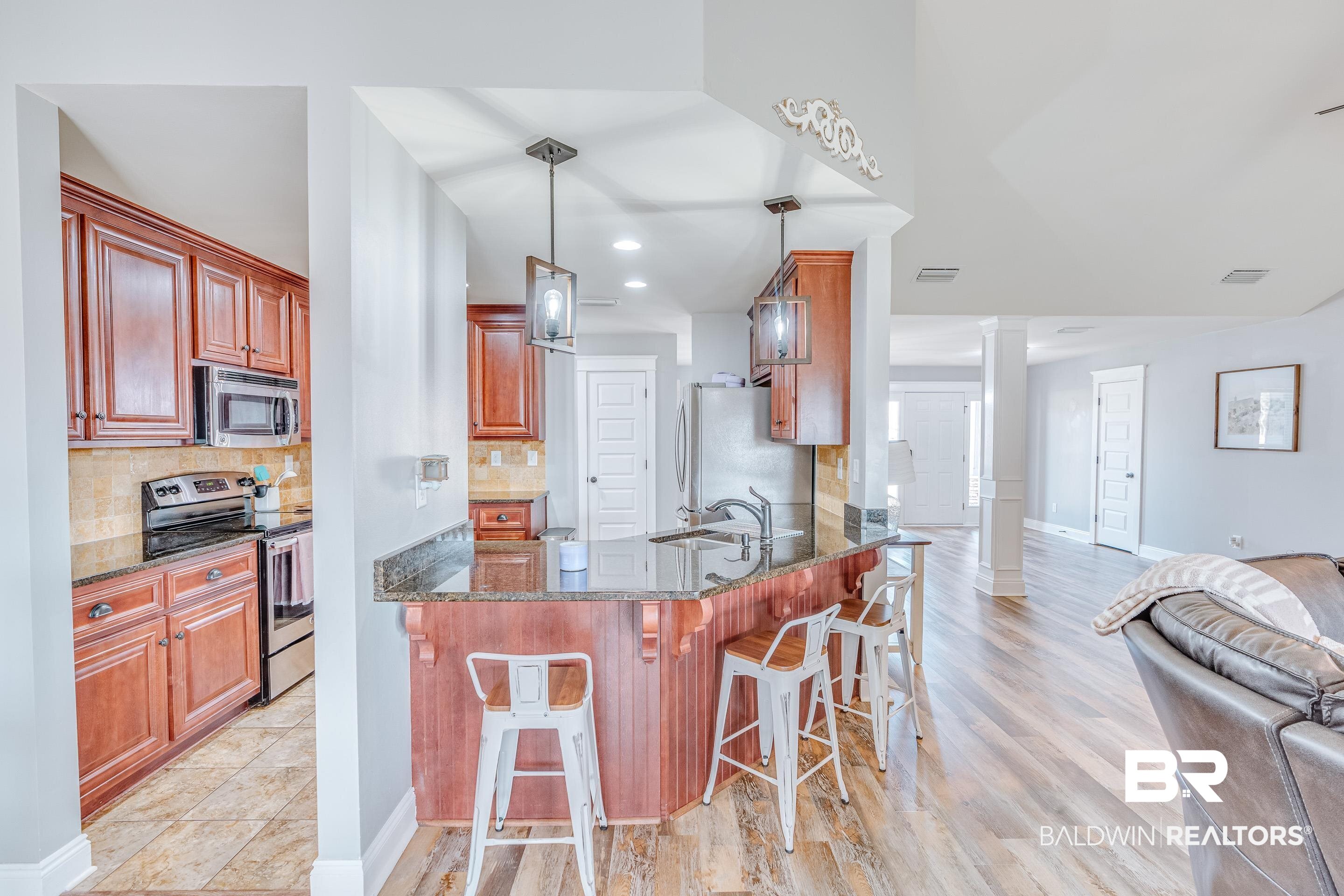 13235 Tom Gaston Road Mobile, AL 36695 - Photo 7 of 43 Kitchen featuring stainless steel appliances, ornate columns, pendant lighting, and kitchen peninsula