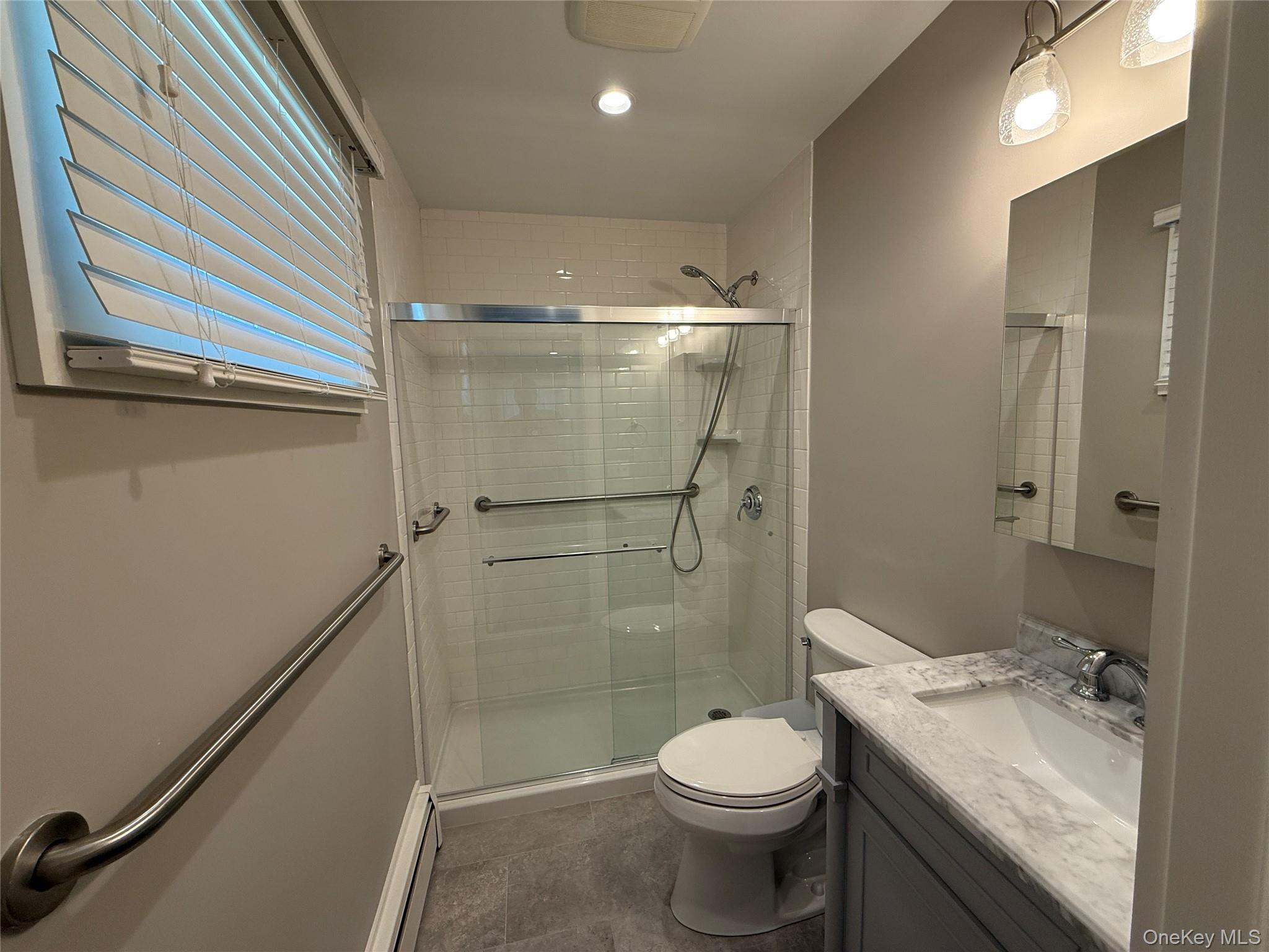 55075 Main Road, Unit YOUNGS BLDG #3 Southold, NY 11971 - Photo 7 of 16 a bathroom with a granite countertop sink toilet and shower