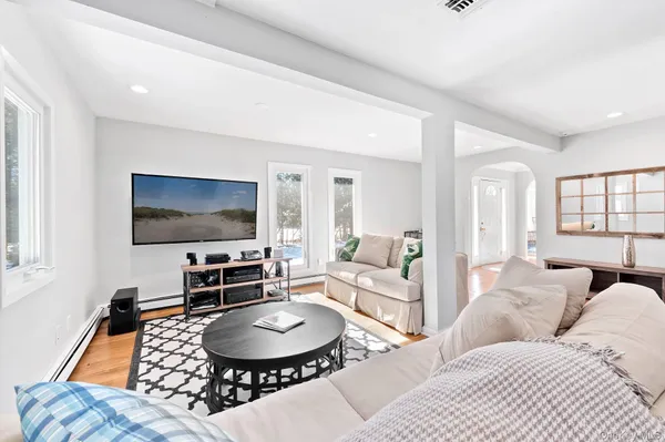 a living room with furniture a flat screen tv and a large window