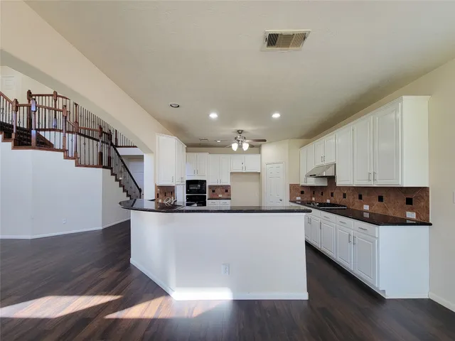 a large white kitchen with a sink and stove