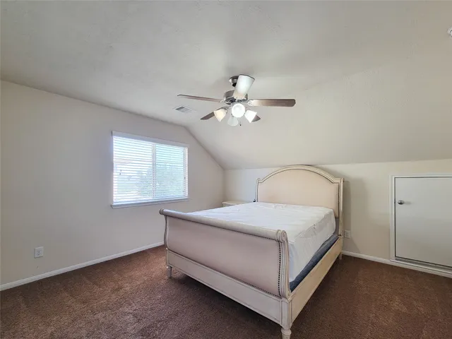 a bedroom with a bed and a ceiling fan