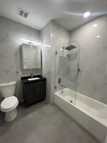 a bathroom with a double vanity sink toilet and bathtub
