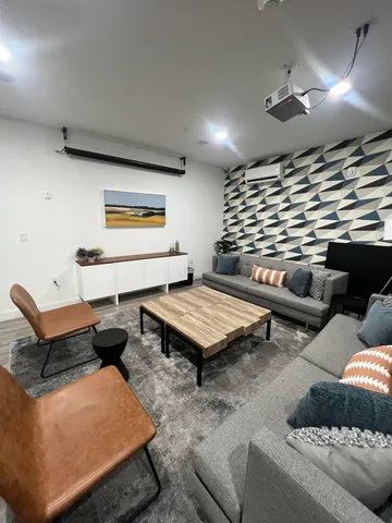 a living room with furniture a rug and a projector