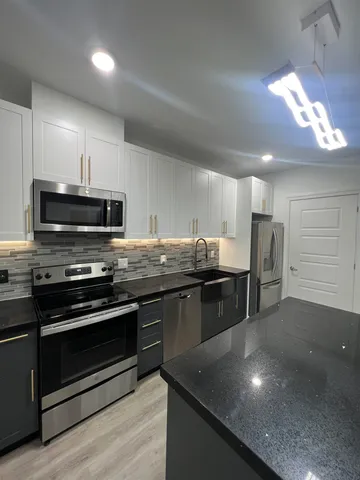 a kitchen with stainless steel appliances and chandelier