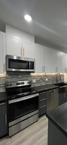 a kitchen with granite countertop a stove and a sink