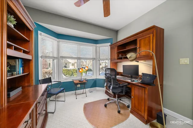 a view of a workspace with furniture and a window