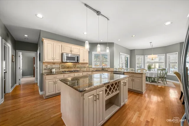 a kitchen with stainless steel appliances granite countertop a stove a sink and a refrigerator