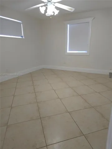 an empty room with a chandelier fan