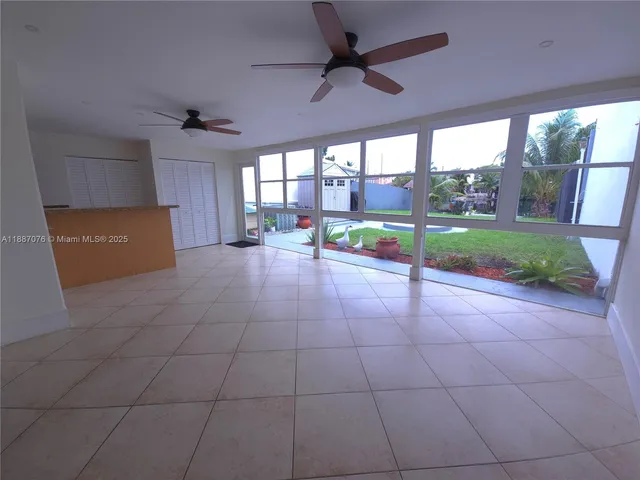 a view of an empty room with a floor to ceiling window and a ceiling fan