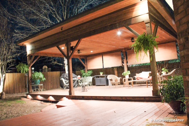 a view of potted plants with a table and chairs under an umbrella