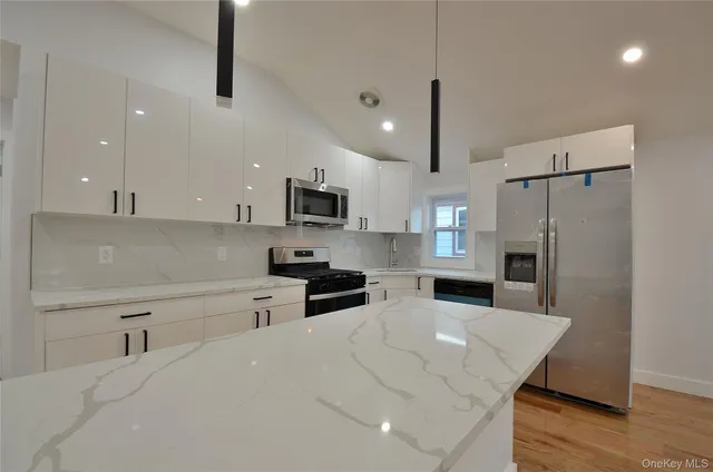 a kitchen with stainless steel appliances a refrigerator sink and microwave