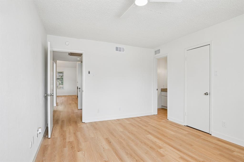 5300 Keller Springs Road, Unit 2055 Dallas, TX 75248 - Photo 9 of 24 Bright room featuring wood-finish flooring, white walls, and a ceiling fan