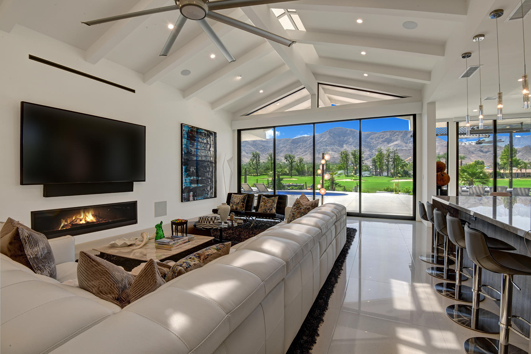 4 Deerfield Court Rancho Mirage, CA 92270 - Photo 8 of 53 a living room with furniture a flat screen tv and a floor to ceiling window