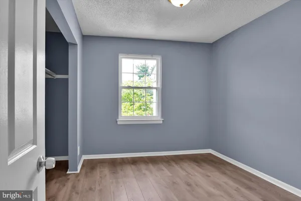 an empty room with wooden floor and a window