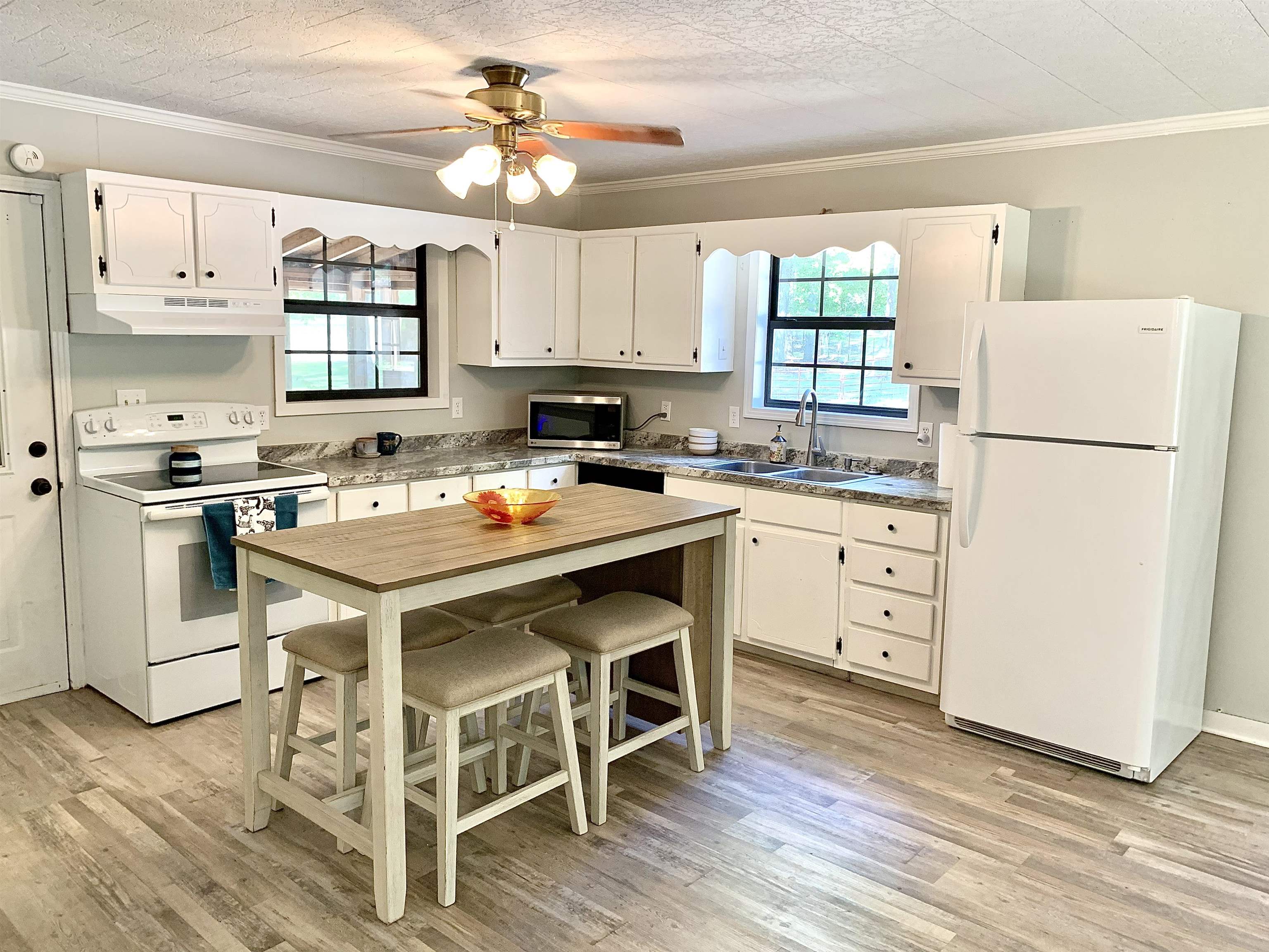 115 Fortune Way Hornsby, TN 38044 - Photo 18 of 30 a kitchen with a table chairs refrigerator and cabinets
