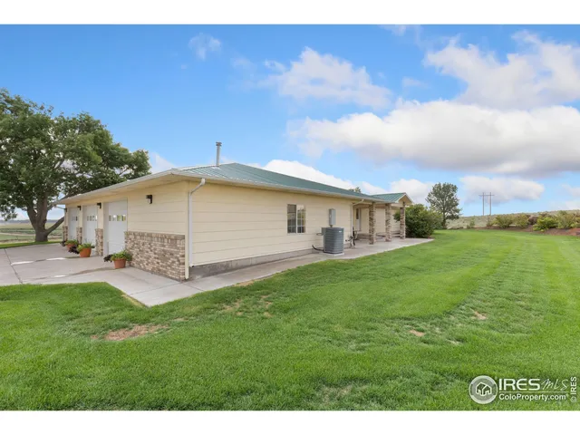 a aerial view of a house next to a big yard with large tree