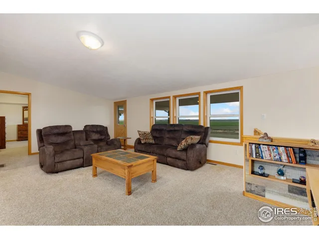 a living room with furniture and a book shelf