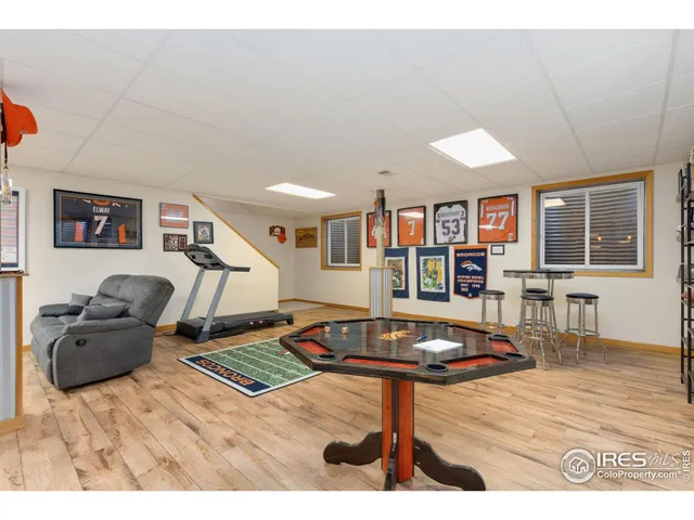 a living room with furniture a piano and a bookshelf
