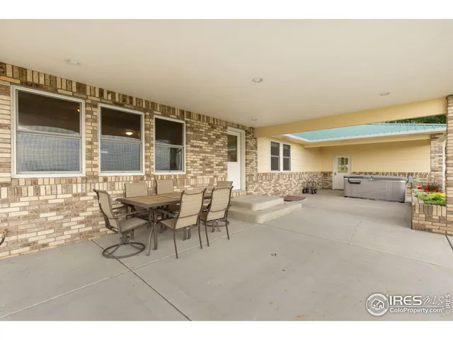 a view of a patio with table and chairs and a barbeque