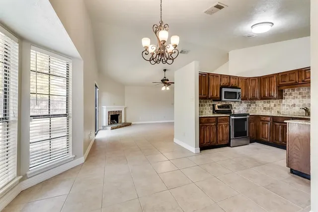 a kitchen with kitchen island granite countertop a stove top oven a sink and a refrigerator
