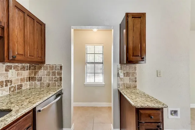 a kitchen with granite countertop a sink stove and cabinets