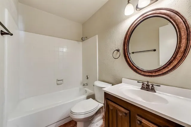 a bathroom with a sink a toilet and a mirror