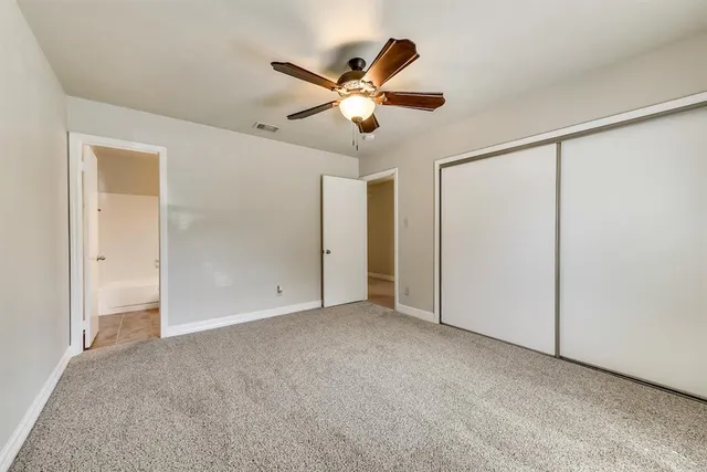 a view of an empty room with a ceiling fan