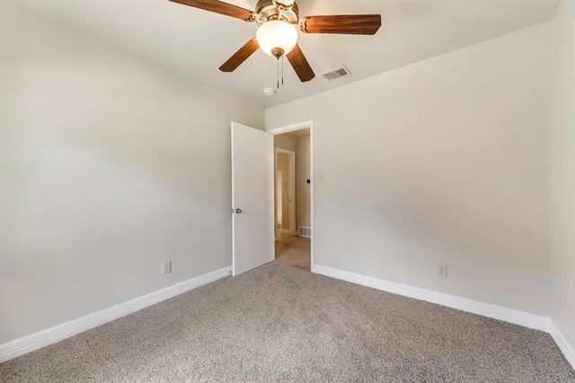an empty room with chandelier fan