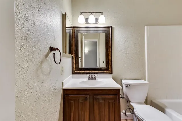 a bathroom with a sink a toilet and mirror