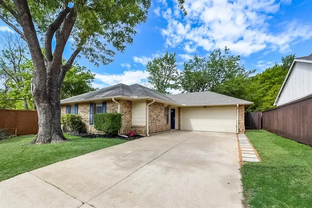 a front view of a house with a yard and trees