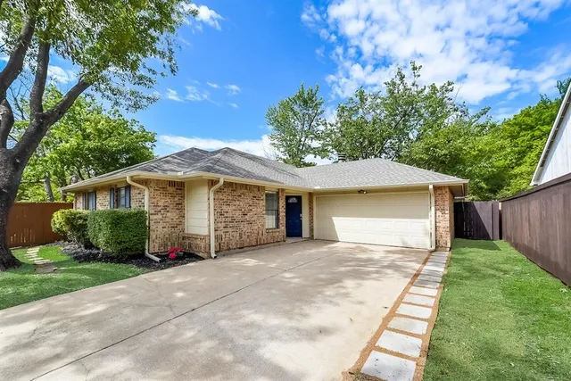 a front view of a house with a yard and potted plants