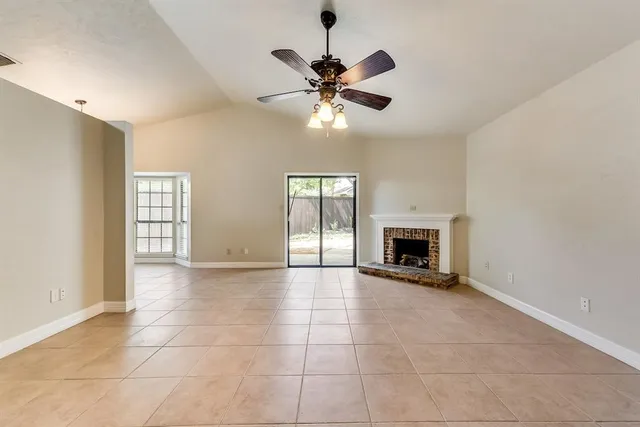 a view of an empty room with a fireplace and a window