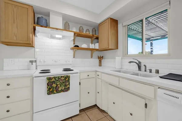 a kitchen with cabinets appliances a sink and a window