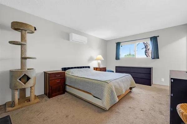 a bedroom with a bed and a lamp on dresser