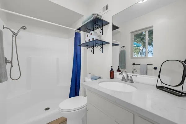 a bathroom with a sink a toilet and shower