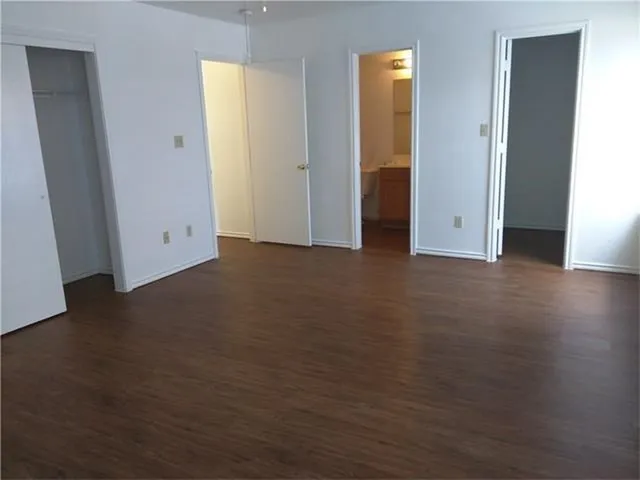 an empty room with wooden floor and closet