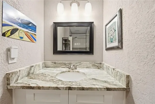 a bathroom with a granite countertop sink and a mirror