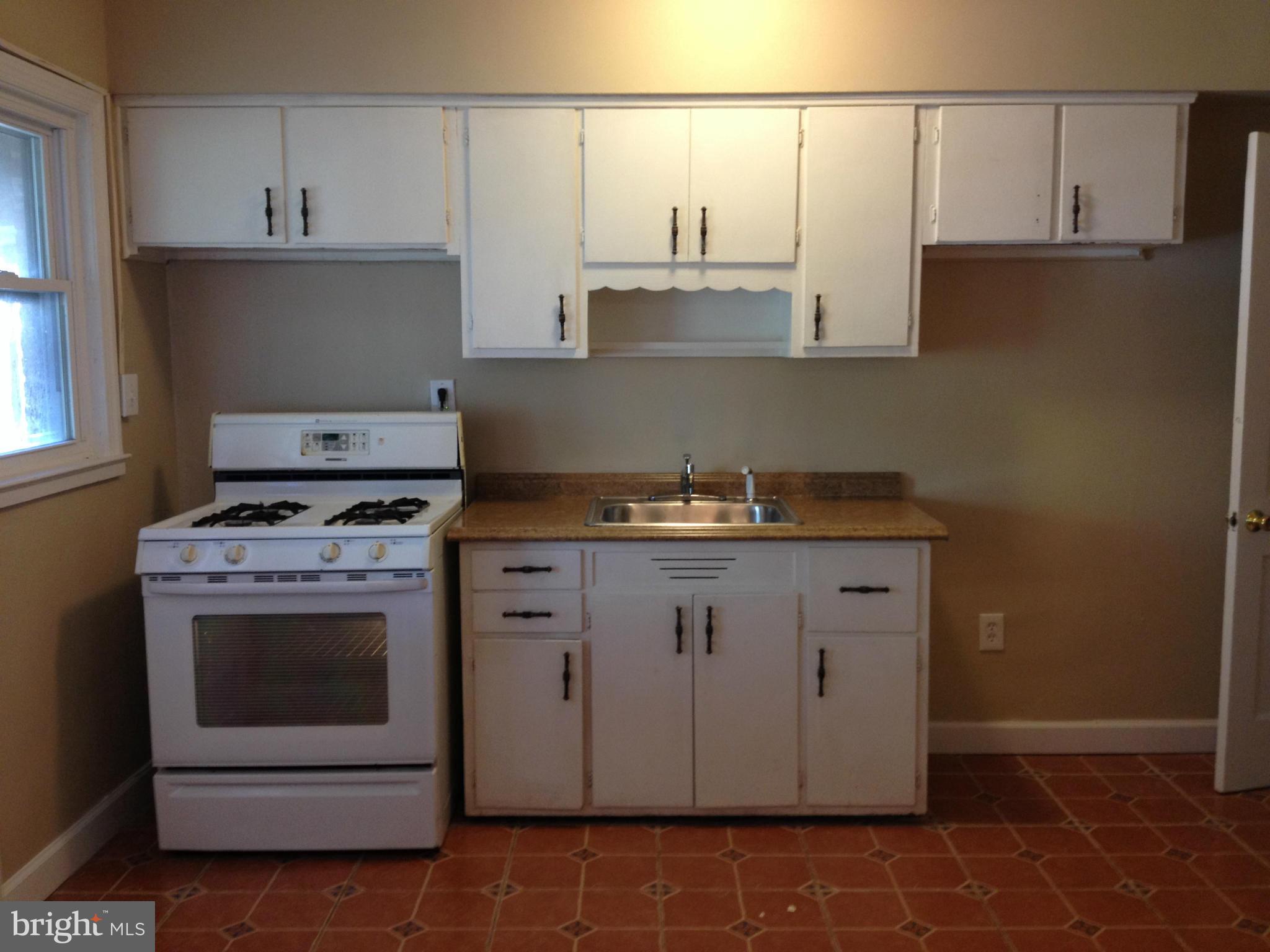 8328 Ridgely Oak Road Parkville, MD 21234 - Photo 4 of 10 a kitchen with granite countertop a sink a stove and cabinets