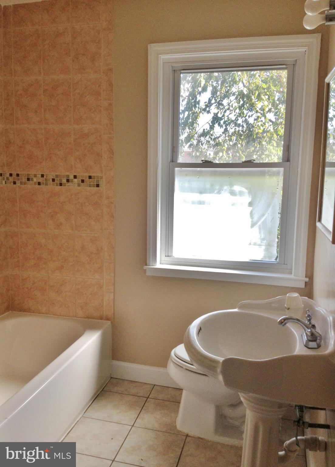 8328 Ridgely Oak Road Parkville, MD 21234 - Photo 8 of 10 a bathroom with a sink bathtub and window