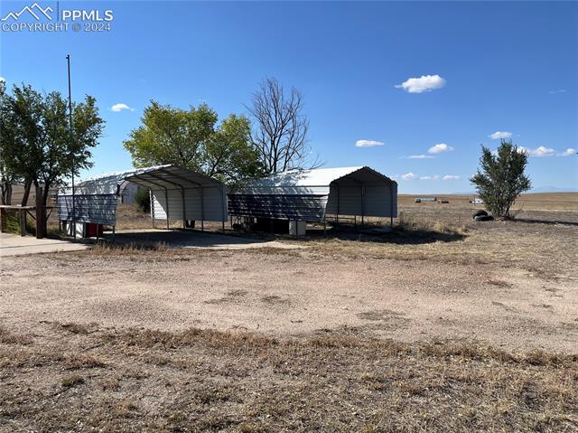 16785 North Yoder Road Calhan, CO 80808 - Photo 3 of 8 View of outdoor structure with a carport and a rural view