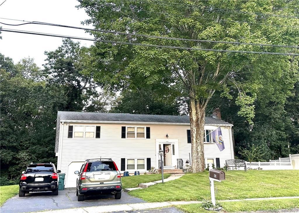 a white house that has a tree in front of it