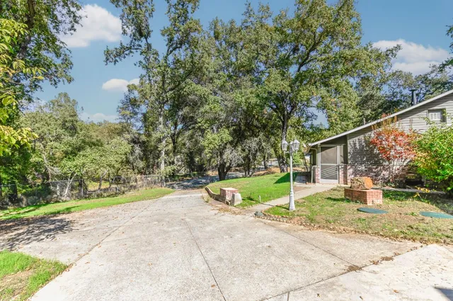 a view of a big house with a big yard and large trees
