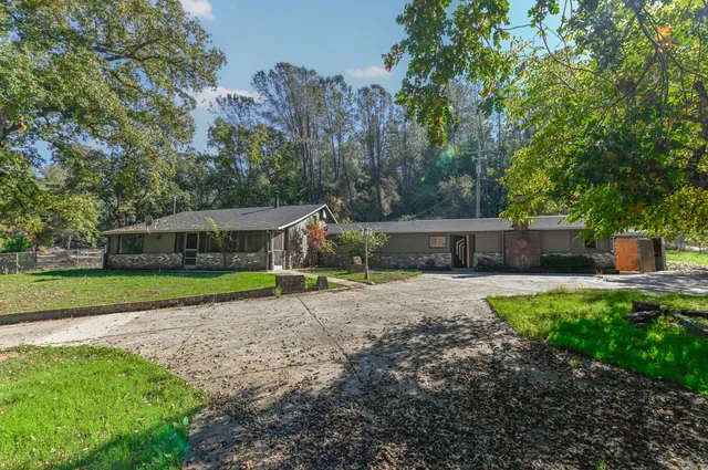 a view of a white house with a yard and sitting area