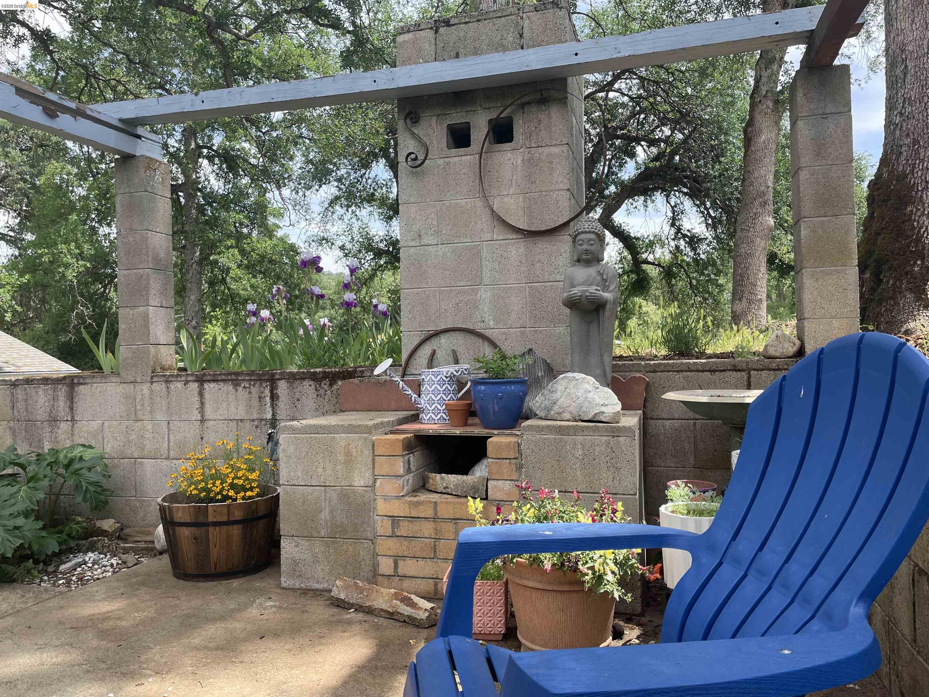 18363 Yosemite Road Tuolumne, CA 95379 - Photo 18 of 34 Outdoor stone and brick fireplace with integrated concrete block pergola framework