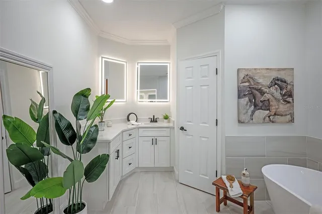 a spacious bathroom with a double vanity sink a mirror and a bathtub