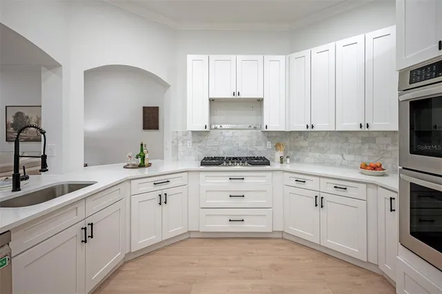 a kitchen with white cabinets and stainless steel appliances