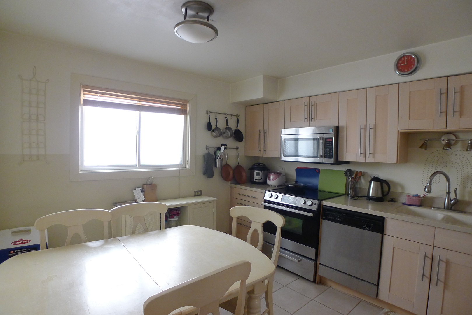 547 Sheridan Road, Unit 1E Evanston, IL 60202 - Photo 6 of 16 a kitchen with a table chairs a sink dishwasher window and cabinets