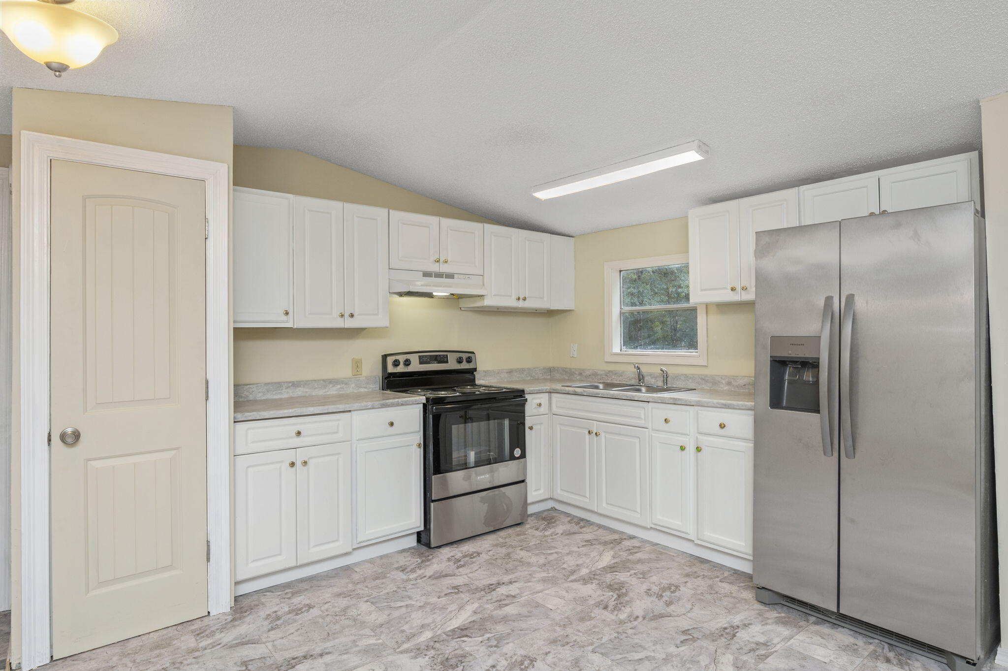 1108 Country Living Road Baker, FL 32531 - Photo 13 of 33 a kitchen with stainless steel appliances granite countertop a refrigerator and a stove top oven