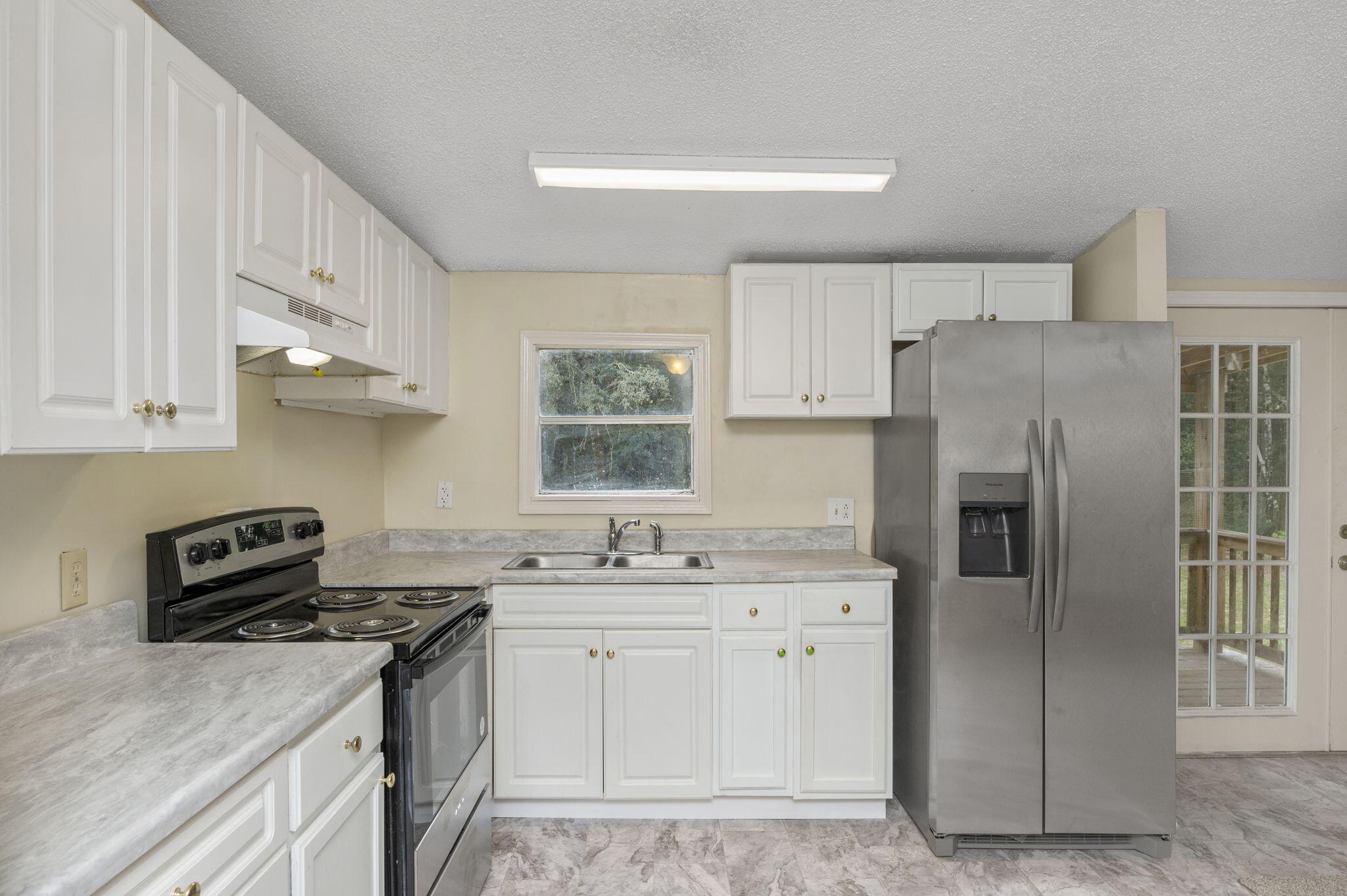 1108 Country Living Road Baker, FL 32531 - Photo 14 of 33 a kitchen with stainless steel appliances a sink stove and refrigerator