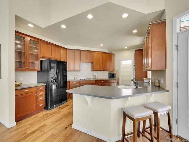 a kitchen with stainless steel appliances granite countertop a sink refrigerator and cabinets